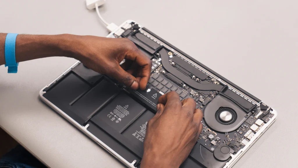 MacBook ouvert en cours de réparation, batterie et ventilateur visibles